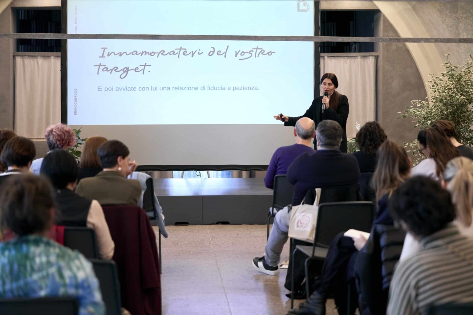 Workshop su Made in Italy, artigianato e impresa durante il Brand Camp, relatrice che parla a una platea davanti a una slide con la frase “Innamoratevi del vostro target”.