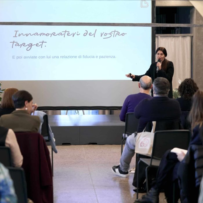 Workshop su Made in Italy, artigianato e impresa durante il Brand Camp, relatrice che parla a una platea davanti a una slide con la frase “Innamoratevi del vostro target”.